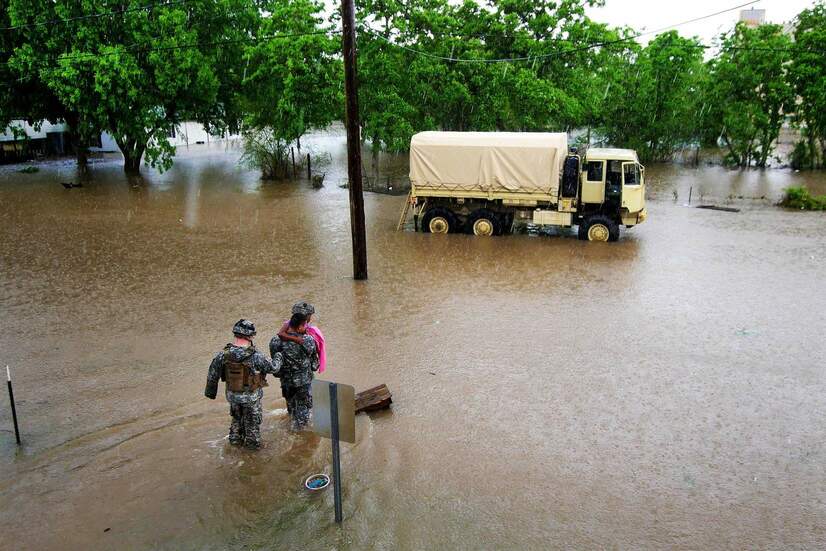 National Guard carries a girl through floodwaters