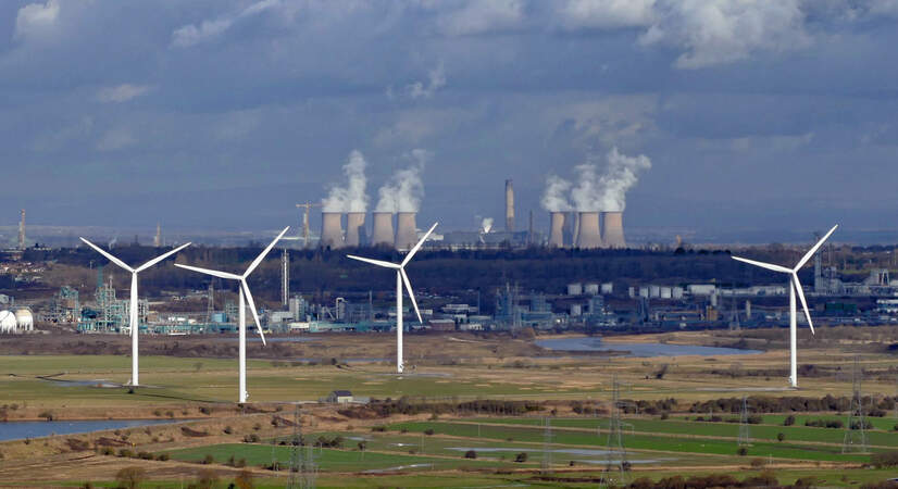 Wind turbines in the foreground of a coal power station at Frodsham Marsh in Cheshire, England. 