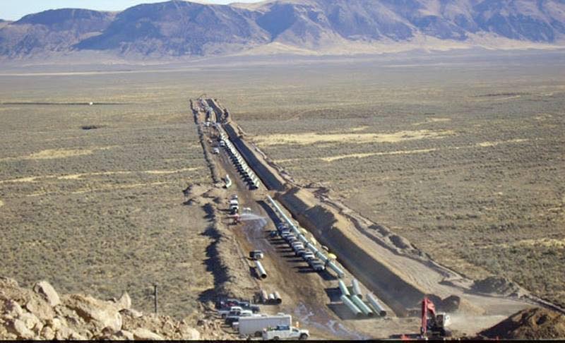 Construction of the Trans-Pecos pipeline in the desert with mountains beyond
