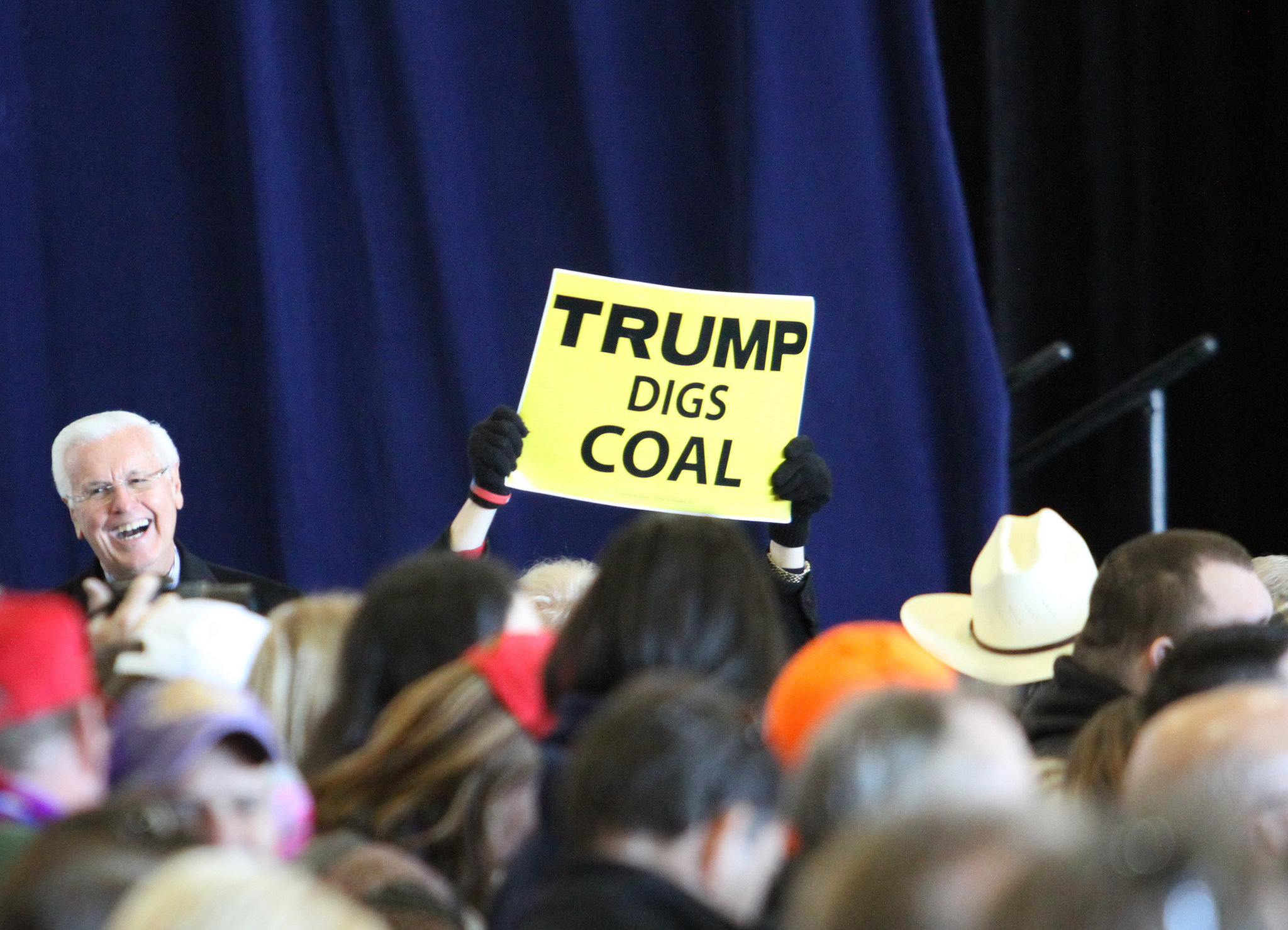 Someone holding a 'Trump digs coal' sign at a rally